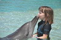 young girl kissing a dolphin at Atlantis