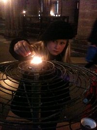 girl lighting a candle in Notre Dame