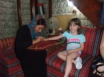 girl having henna done at Dubai museum