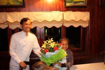 keira getting flowers on junk in Halong Bay