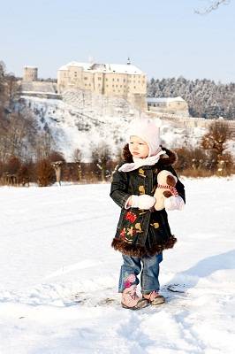 girl with Cesky Sternberk Castle in winter at background, Czech Republic