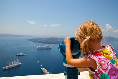 Young girl looking at cruiseships inSantorini, Greece